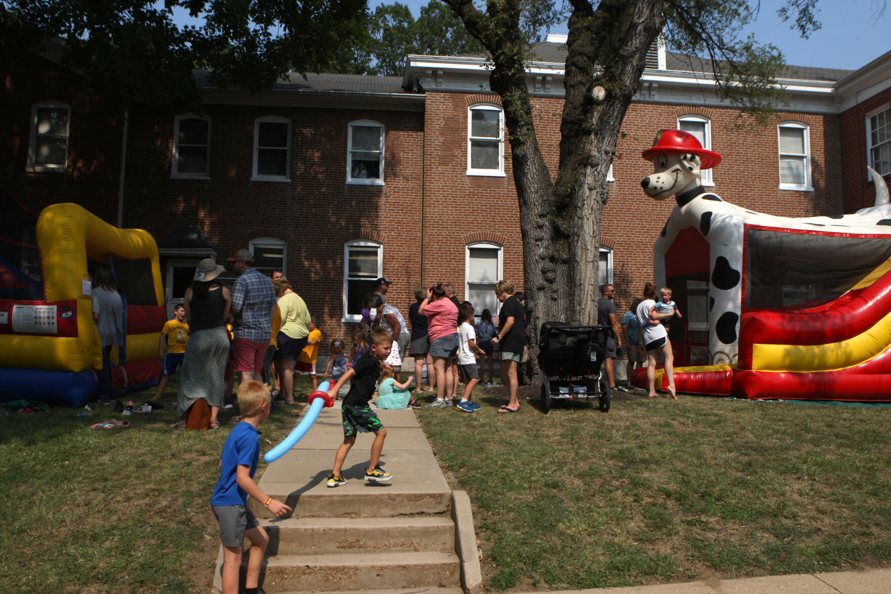 People wait outside bounce houses